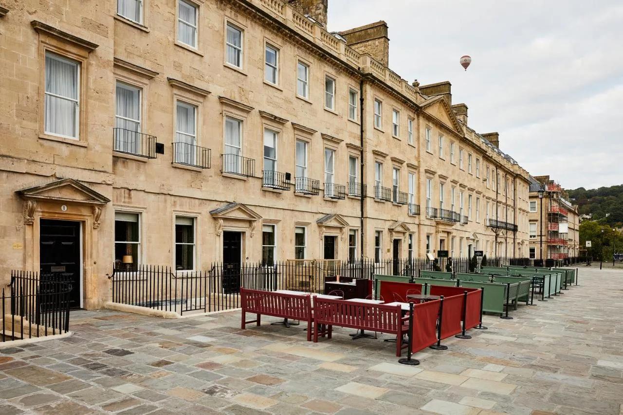 a row of red benches in front of a building at Hotel Indigo - Bath by IHG in Bath
