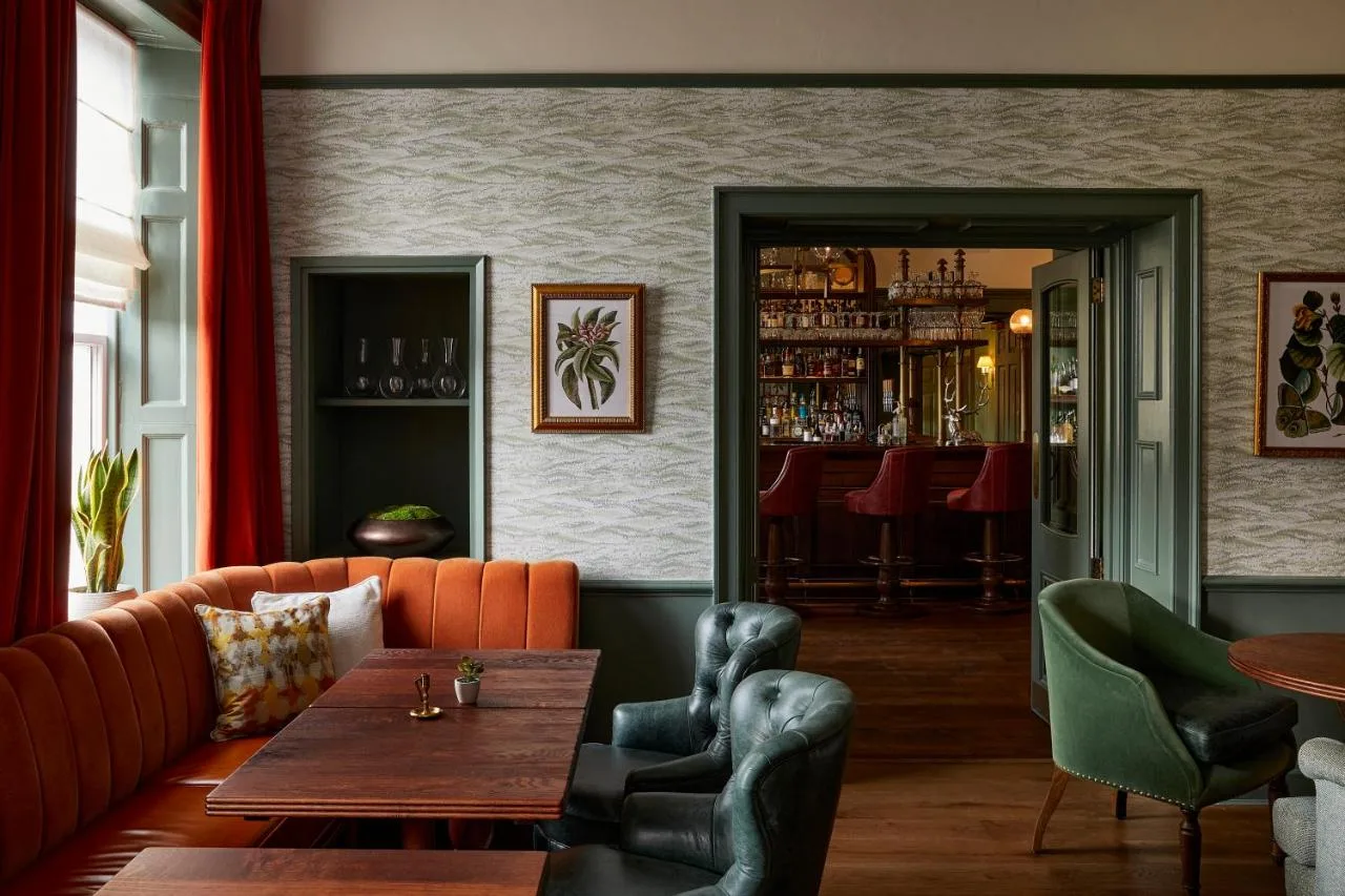 a bar with a couch and a table and chairs at Hotel Indigo - Bath by IHG in Bath