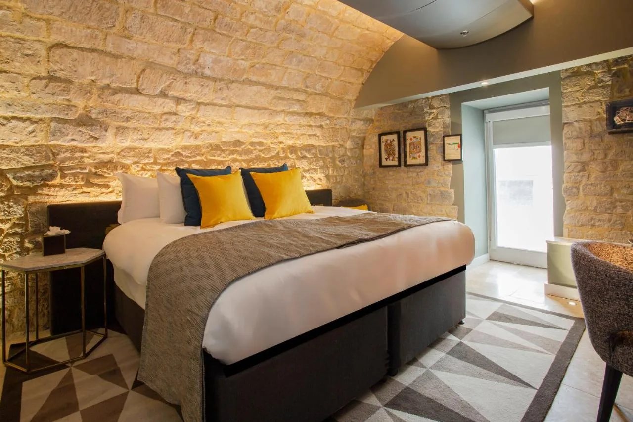 a bedroom with a large bed with yellow pillows at Hotel Indigo - Bath by IHG in Bath